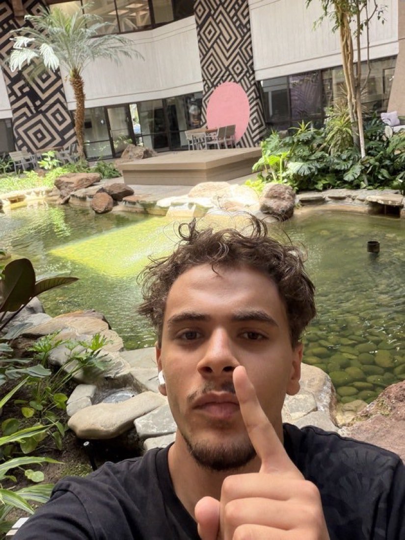 Yusuf Gadelrab, casual selfie in a plant-filled atrium on campus