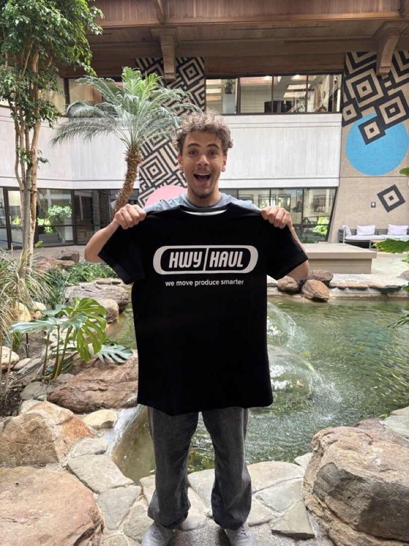 Yusuf Gadelrab excitedly holding up a HwyHaul t-shirt
